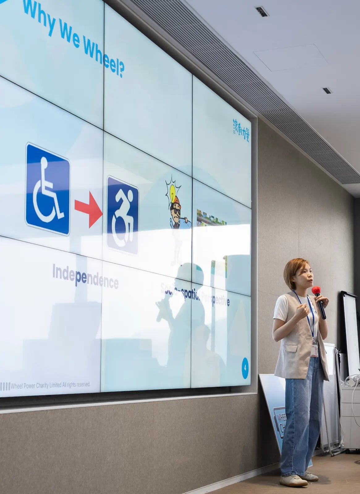 Sarah speaking with a microphone at a Wheel Power Charity talk on accessibility